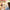A woman relaxes on a couch reading a book in a bright room, with a small red and black cooling fan placed on a table beside her. Large text at the top reads 'QUIET AMBIENT COOLING' and 'Perfect for Reading & Relaxing.